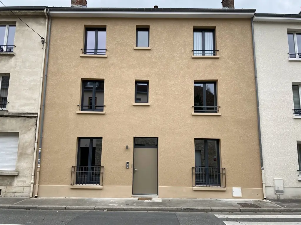 Façade de maison ravalée, enduit minéral gratté teinte sable